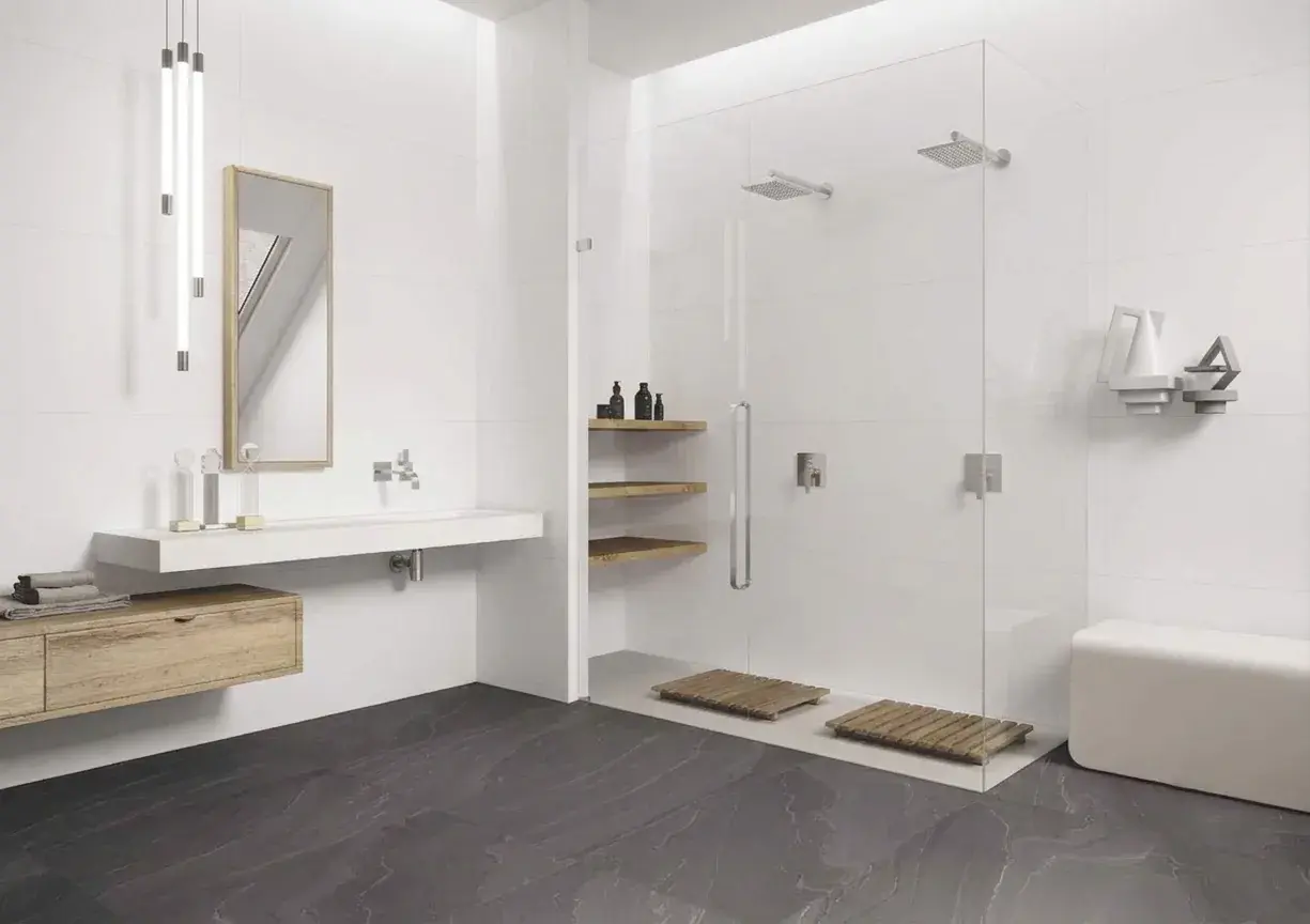 Salle de bain moderne avec sol en grès cérame effet pierre et grande douche en verre