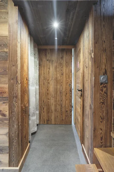 Porta | Porta d'ingresso in legno antico a doghe verticali, corridoio con pareti e soffitto in legno antico